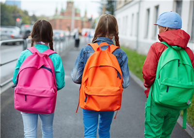  kids with backpacks walking
